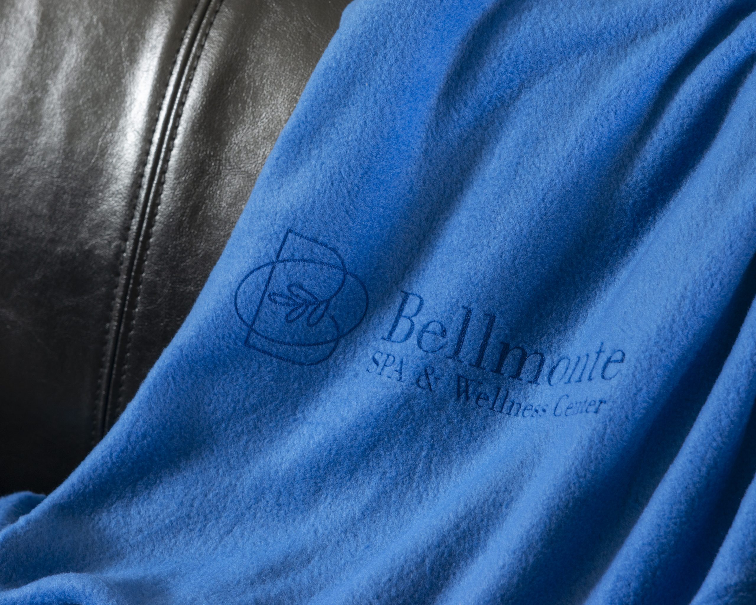 A blue laser engraved towel draped over black leather in the background.