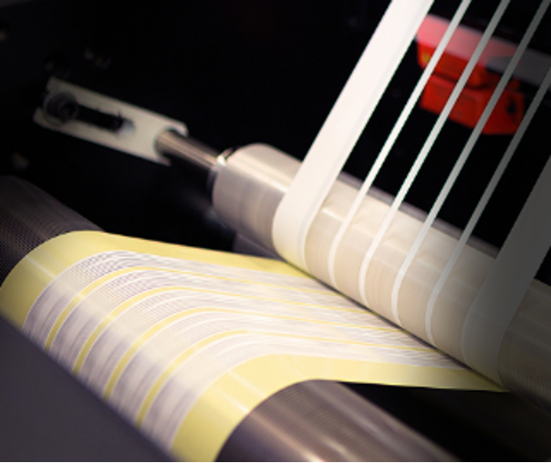 Industrial CO2 laser machine kiss-cutting self-adhesive labels during continuous production
