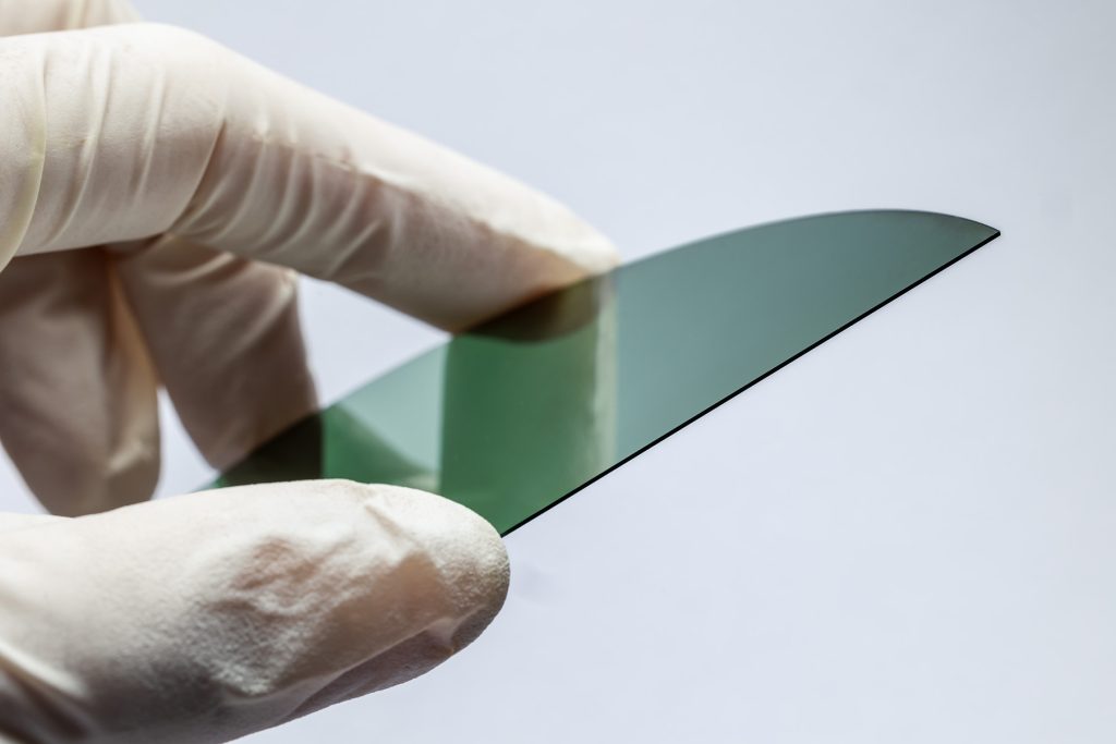 A hand holding a small translucent plate.
