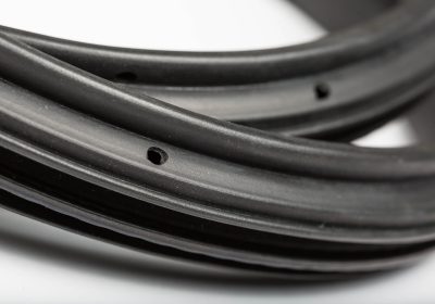 Laser drilling of automotive rubber door seal Close-up of black rubber automotive door seals with laser-drilled holes