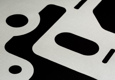 Close-up of laser-cut automotive airbag fabric showing trimmed shapes